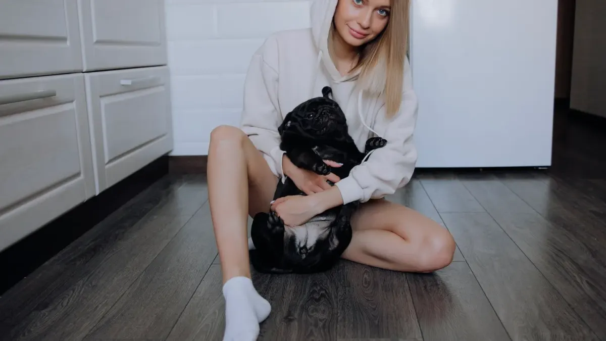 A dog owner reading the label on a supplement bottle at a kitchen counter