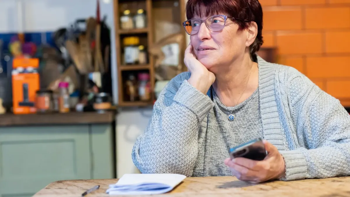 Owner reading the ingredient panel on a dog supplement package in a kitchen